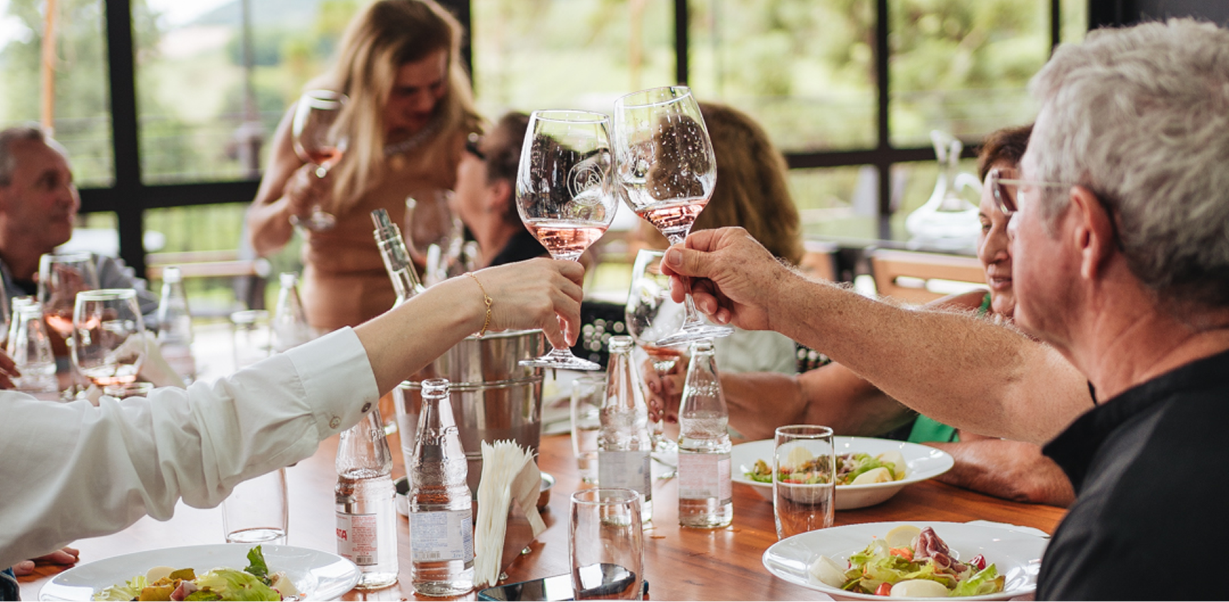 Refúgio gastronômico: pessoas brindando à mesa com taças de vinho